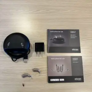 used oticon more 3 product listing with hearing aids, standard charger, wall plug, and manuals