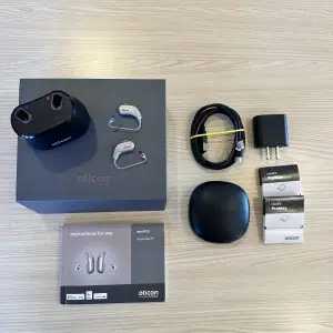 used oticon intent 1 hearing aids for sale with standard charger, cable, wall plug, carrying case, manuals, and wax guards